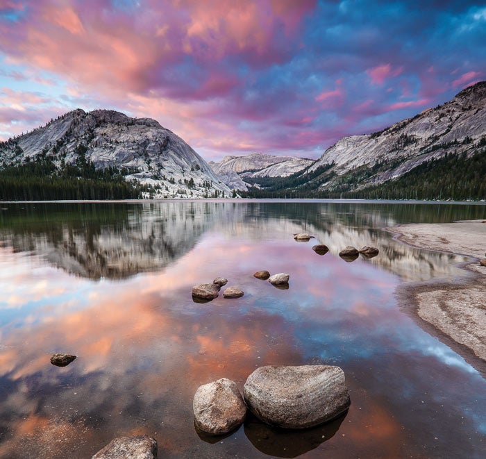 O sol se põe sobre Tenaya Lake fora Tioga Road, no Parque Nacional de Yosemite