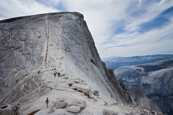 Hikers using the assistance of cables to scale Half Dome in Yosemite National Park